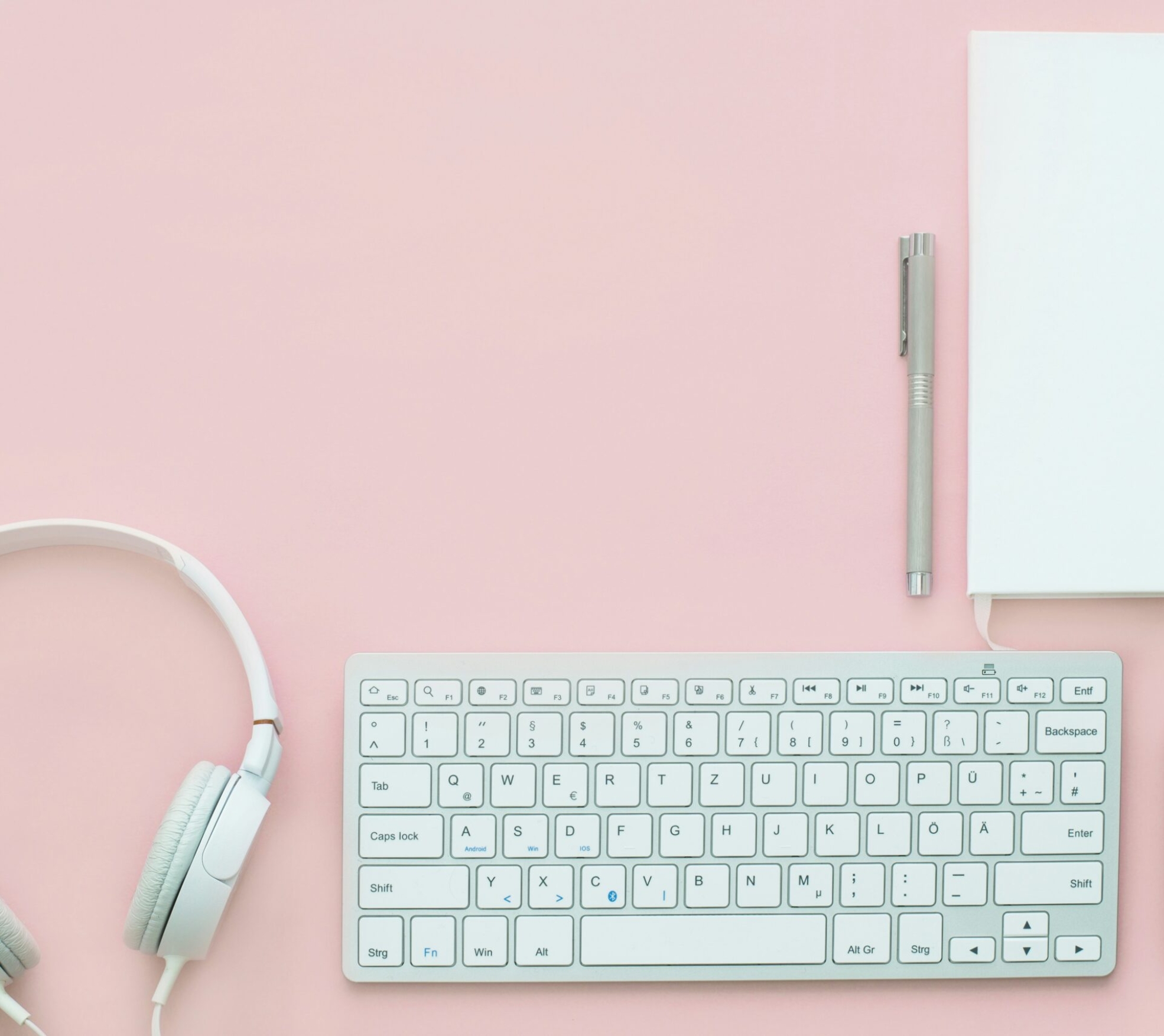 white Apple Magic Mouse beside of Magic Keyboard and headphones